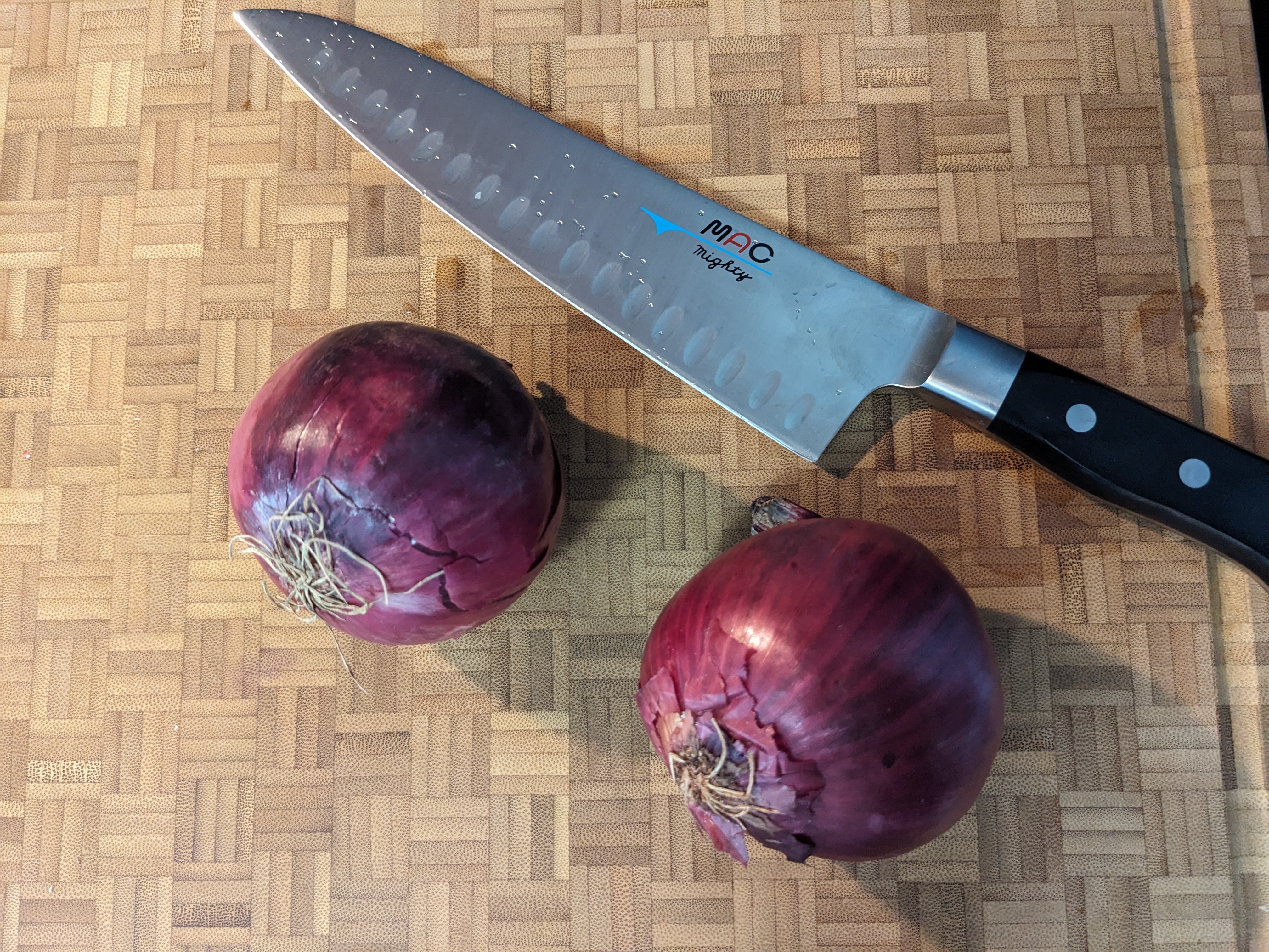 Oignons rouges et couteau sur une planche à découper